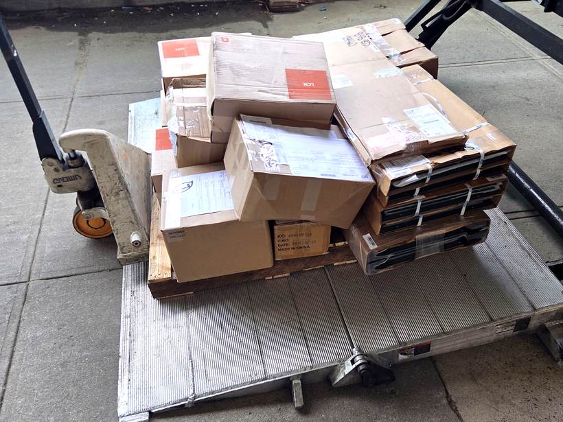 Palletized boxes staged on a pallet jack at a loading dock for delivery