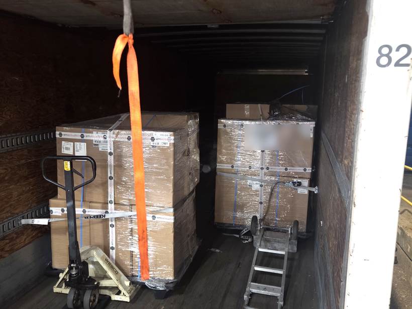 Two full pallets of shrink-wrapped freight loaded in Heavy Hitter's box truck, ramp and pallet jack staged for delivery
